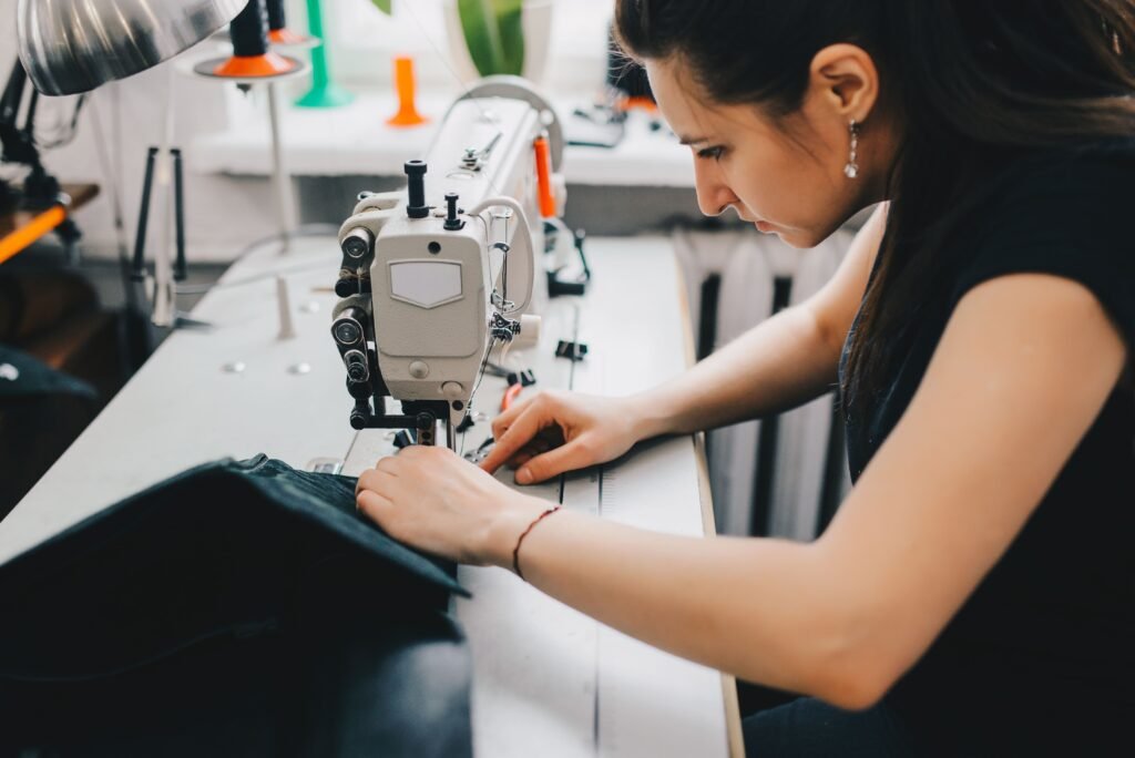 female-artisan-threading-black-leather-sewing-machine