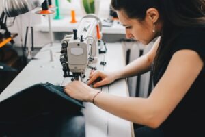 female-artisan-threading-black-leather-sewing-machine